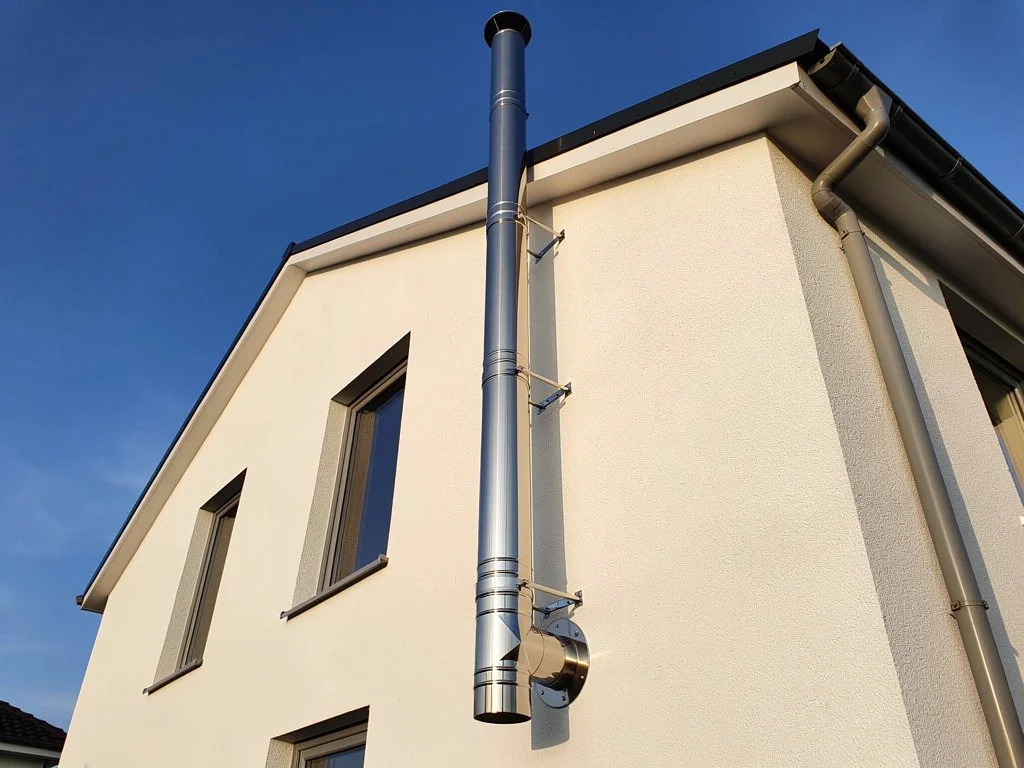 Conduit de fumée inox double paroi tubé le long d'une façade crépie